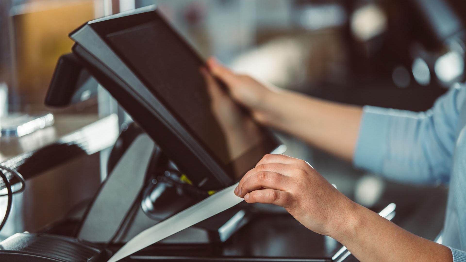 Saleswoman creating payment by card terminal in the shopping center, POS system